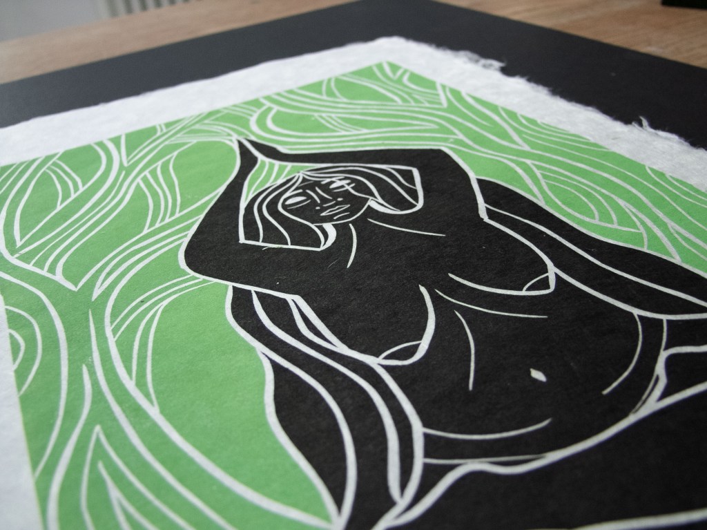 A linocut print depicting a woman with flowing hair and a serene expression, surrounded by swirling green patterns symbolizing nature and earth.