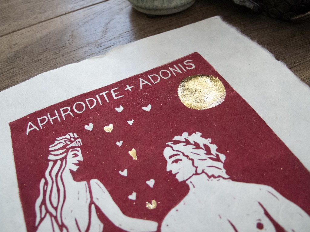 close up of the gold leaf moon on red linocut of two greek lovers