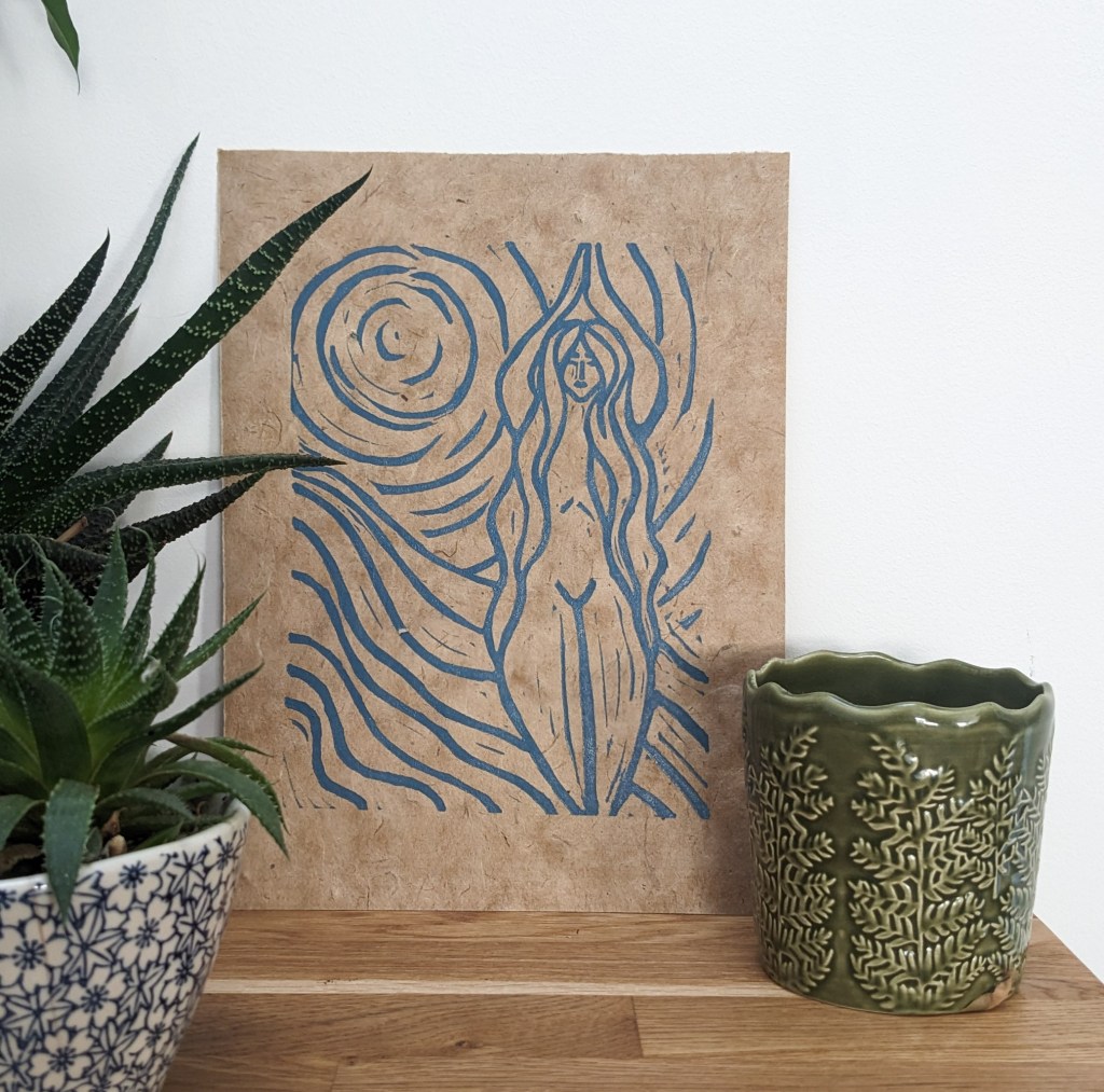 A hand-printed linocut artwork depicting the goddess Achelois, featuring flowing lines and blue ink on textured brown paper, set against a white background with potted plants nearby.
