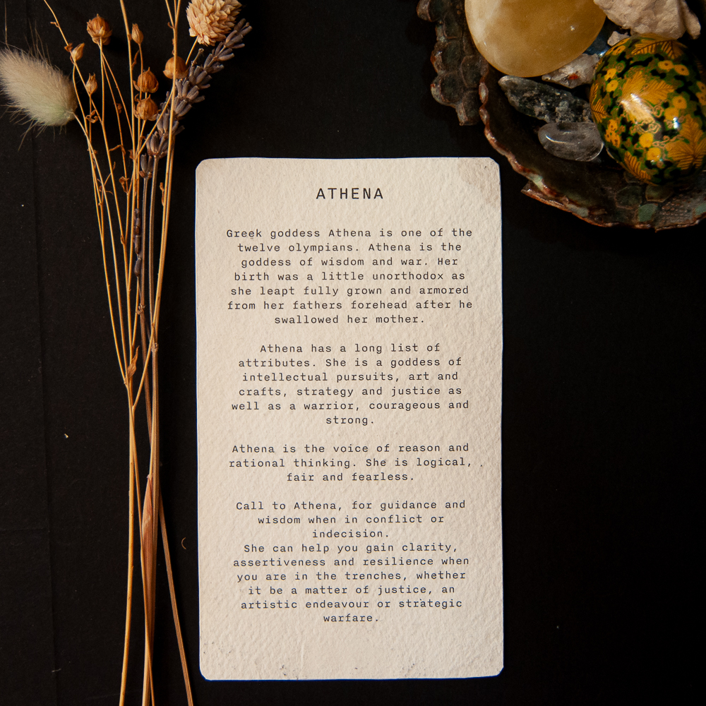 Reverse of Athena Oracle card Black bacground with whote oracle card back with text about athena goddess